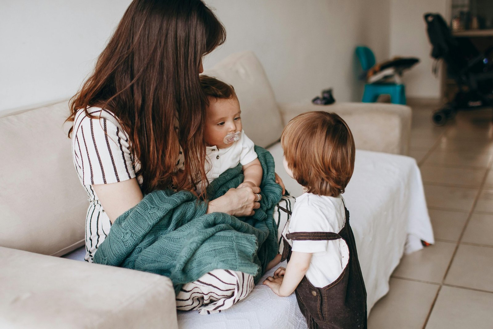 Home Mother and children share a warm moment on the sofa, filled with love and togetherness.